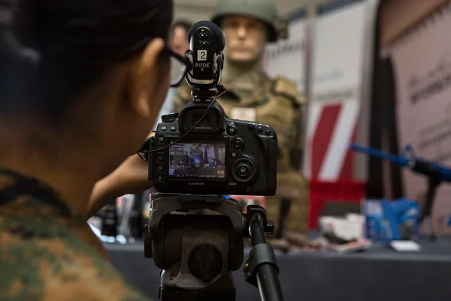 U.S. Marine Corps Lance Cpl. Daphne Rodriguez, combat videographer with Marine Corps Installations East, Camp Lejeune, films a video sequence during the Marine South Military Exposition at the Goettege Field House, Camp Lejeune, N.C., April 7, 2016. The Marine South Exposition is sponsored by the Ma. US-Canada Shoots: Videography Company Operations