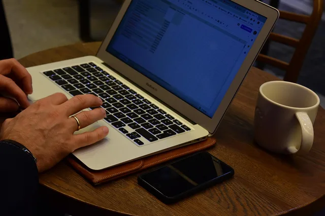work, computer, laptop, writing, analysis, coffee, mug, telephone, iphone, coffee cup, ring, guy, table, hands, cafe. In-House vs Outsourcing Video Editing for a Small Videography Company