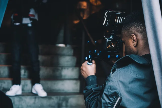 people, man, guy, african american, video, camera, cameraman, photography, blue video, blue camera, blue videos, blue photography, camera, cameraman, cameraman, cameraman, cameraman, cameraman. Videography Day Rate vs Project Rate: Which Protects Your Margin?