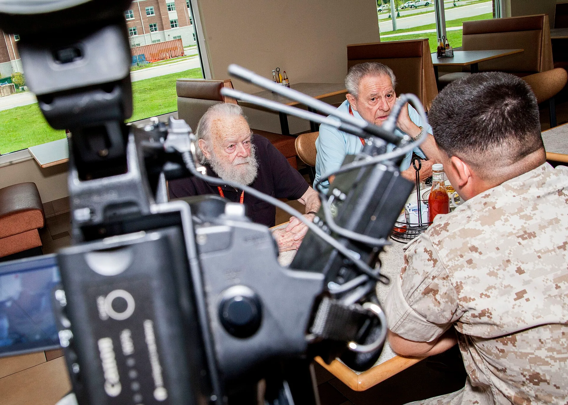 U.S. Marine Corps Staff Sgt. Albert Carls, far right, a combat videographer with Marine Corps Installations East Combat Camera, interviews Mr. Ed Cavalinni, center, and Mr. Chuck Harton, center right, at the Yale Haerter Mess Hall on Camp Lejeune, N.C., Aug. 5, 2015. Veterans of 4th MARDIV and their. Videography marketing: how a business wins customers